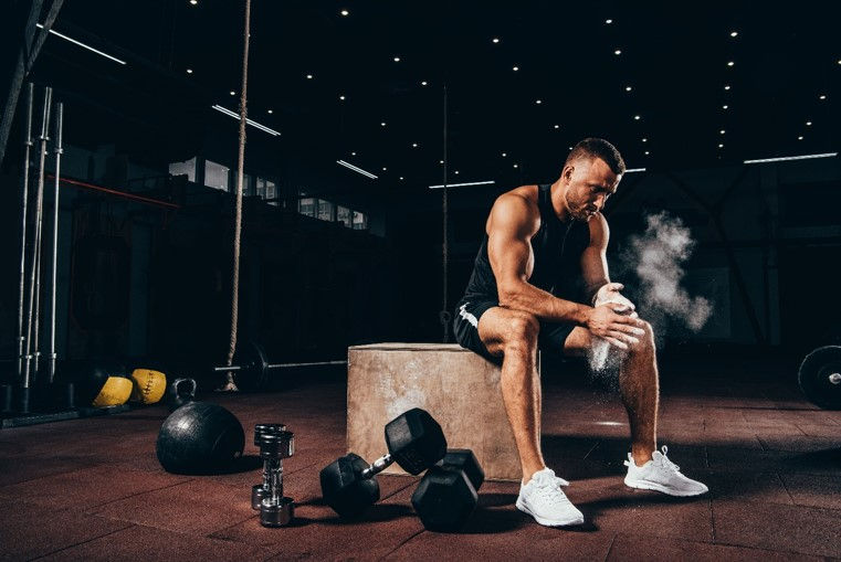 hombre en un gimnasio sentado en un taburete